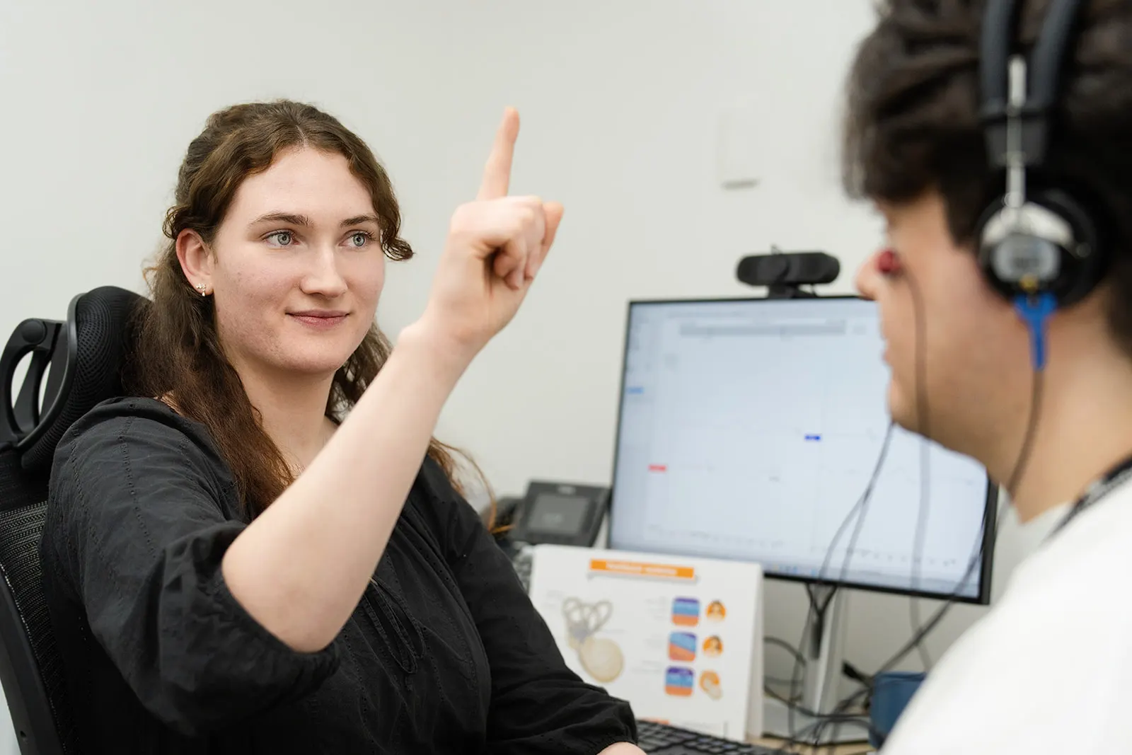 A clinician preparing a patient for vestibular evoked myogenic potential (VEMP) testing